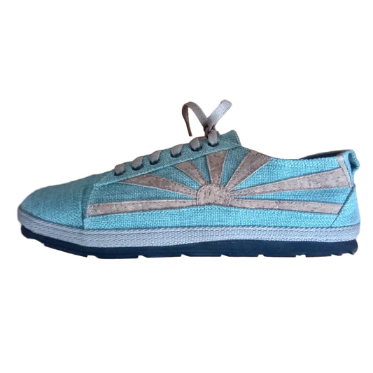 Green hemp sneaker with a sunburst design on a wooden surface
